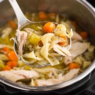 instant pot chicken noodle soup in a pressure cooker with serving ladle