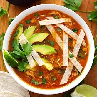 instant pot chicken tortilla soup in a white bowl next to corn tortillas