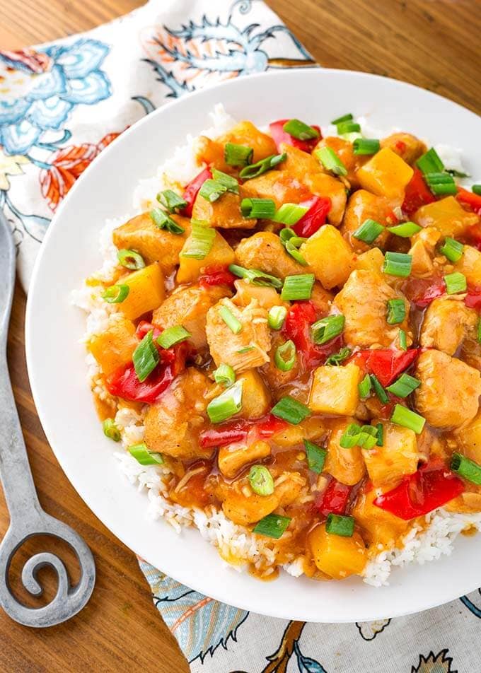 Hawaiian Chicken and Rice on white plate on top of wooden board