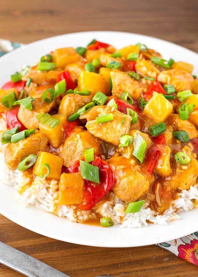 Hawaiian Chicken and Rice on white plate on top of wooden board