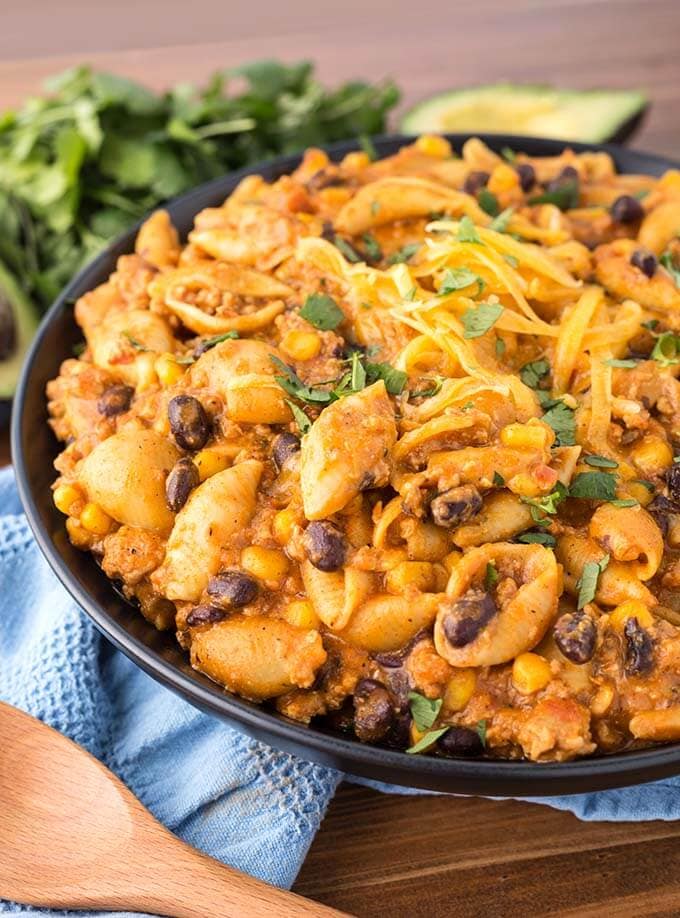 Loaded Taco Pasta on a black plate in front of fresh cilantro