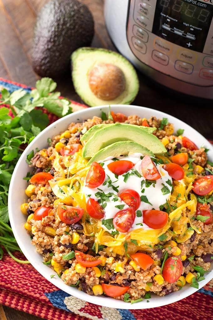 Quinoa Taco Bowl in a white bowl in front of a pressure cooker