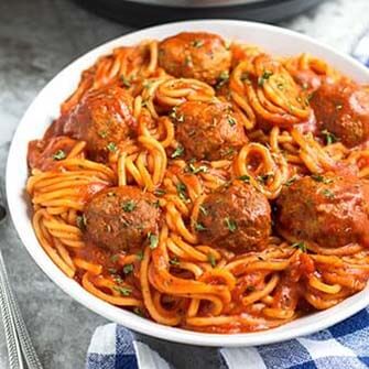 spaghetti and meatballs on a white plate