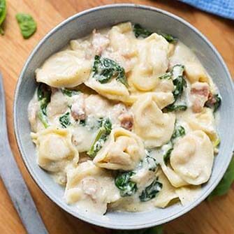 tortellini alfredo in a gray bowl