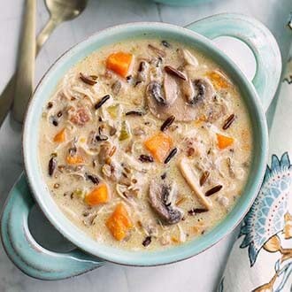 instant pot wild rice soup with chicken in a blue two handled bowl