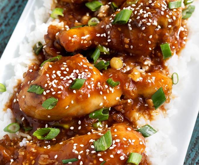 Closeup of Honey Garlic Chicken over rice on white platter