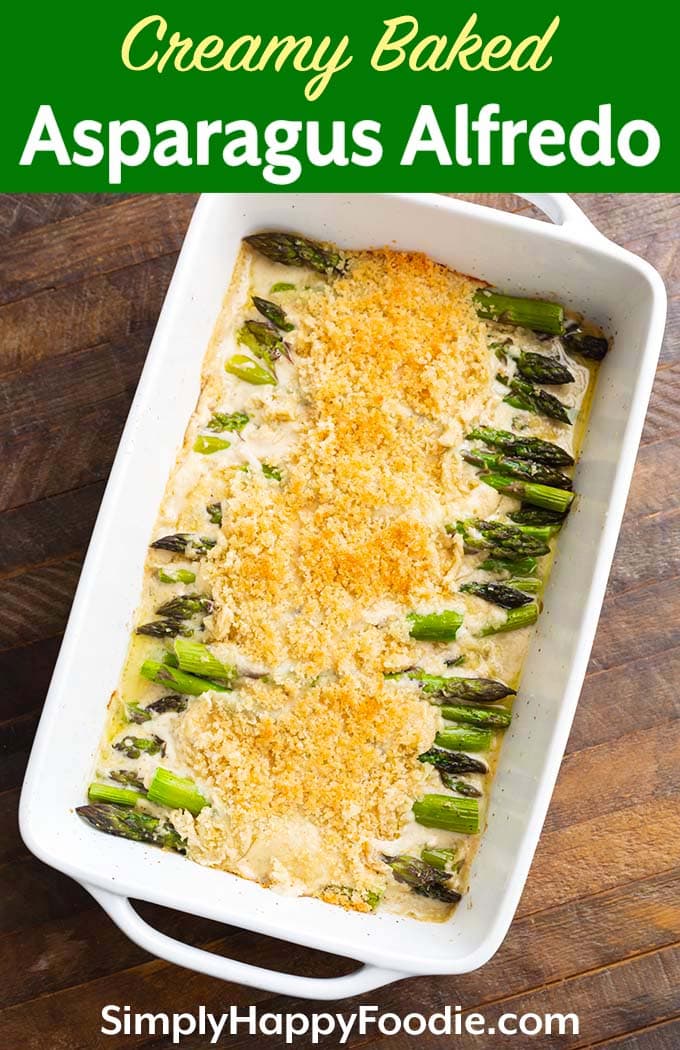 Creamy Baked Asparagus Alfredo in white baking dish on wooden background with title and Simply Happy Foodie.com logo