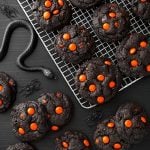 Dark Chocolate Halloween Cookies on cooling rack next to black plastic spiders and snakes