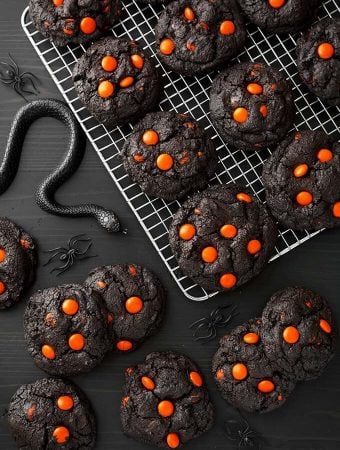 Dark Chocolate Halloween Cookies on cooling rack next to black plastic spiders and snakes