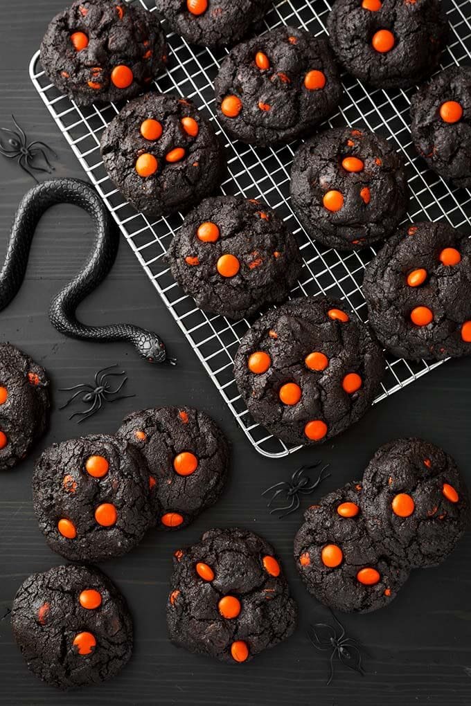 Dark Chocolate Halloween Cookies on cooling rack next to black plastic spiders and snakes