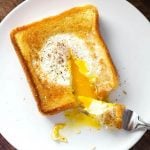 Egg in a Hole on a white plate with fork