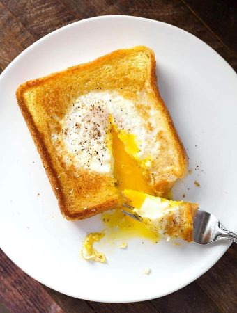 Egg in a Hole on a white plate with fork