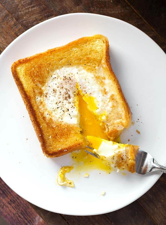 Egg in a Hole on a white plate with silver fork
