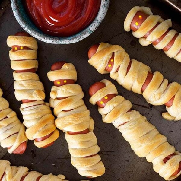 halloween hot dog mummies on a tray with ketchup