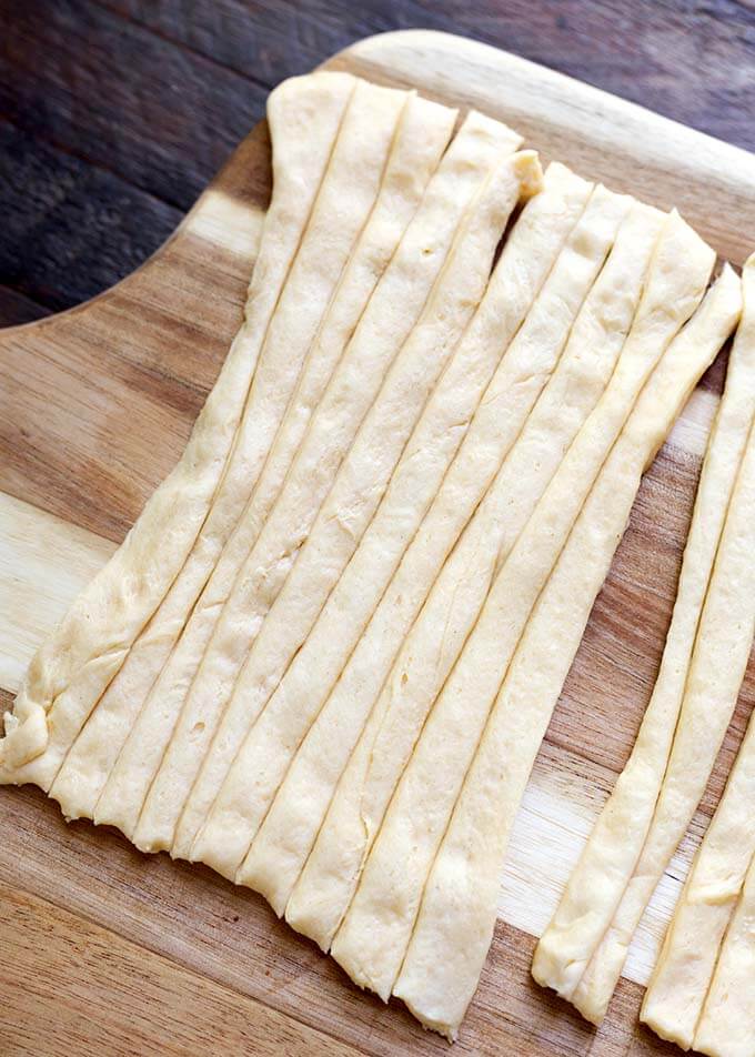 Long Cut strips of dough on wooden board