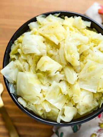Buttered Cabbage in a black bowl on wooden surface