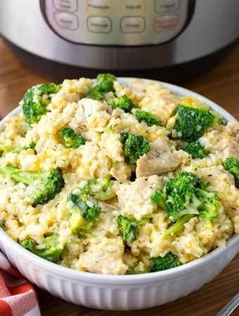 Chicken Broccoli Rice Casserole in a white bowl in front of a pressure cooker