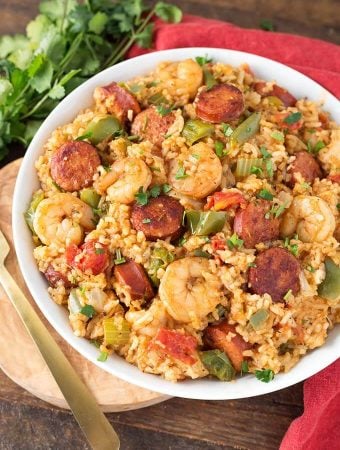 Jambalaya in a white bowl on a wooden board