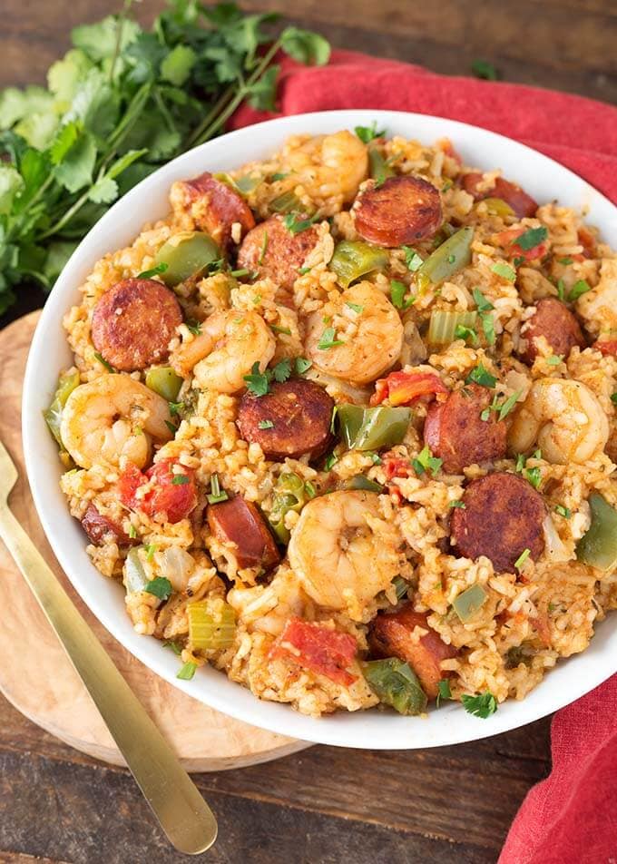 Jambalaya in a white bowl on a wooden board