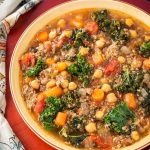 Tuscan Sausage Kale Soup in brown bowl on wooden board