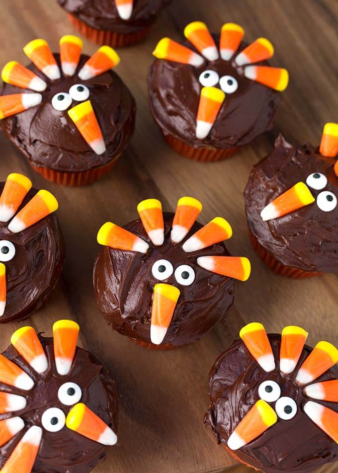 Several Candy Corn Turkey Thanksgiving Cupcakes on a wooden board