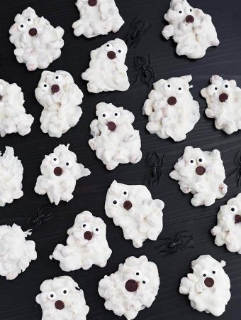 White Chocolate Halloween Ghosts and black plastic spiders on dark wood background