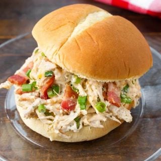 Slow Cooker Crack Chicken on a hamburger bun on a glass plate