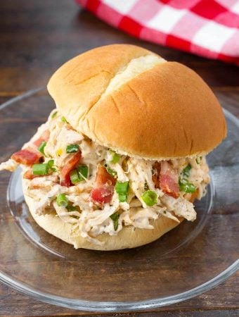 Slow Cooker Crack Chicken on a hamburger bun on a glass plate