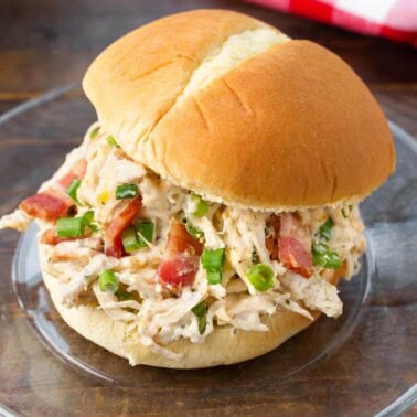 Slow Cooker Crack Chicken on a hamburger bun on a glass plate
