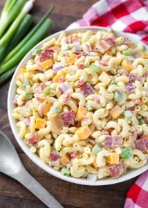 Classic Macaroni Salad in white bowl next to red gingham napkin and silver spoon