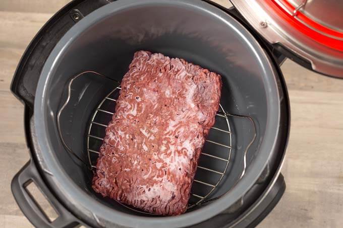 Frozen Ground Beef on a trivet in a pressure cooker