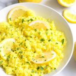 Instant Pot Lemon Rice on a white plate with sliced lemons