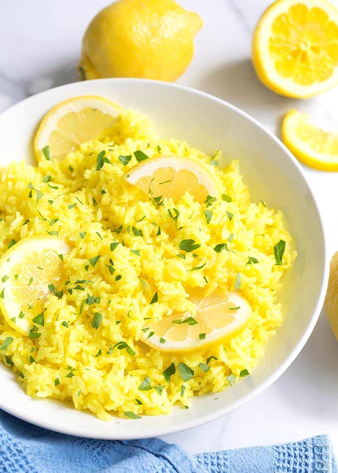 Lemon Rice in a white bowl with sliced lemons