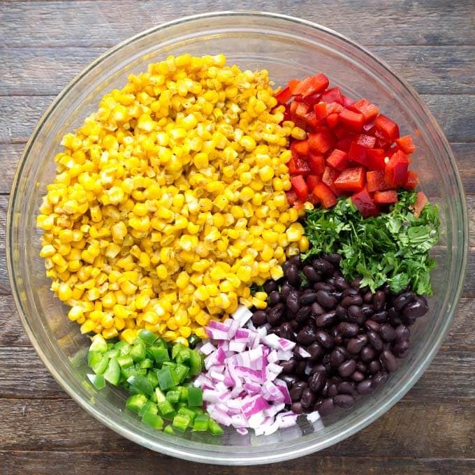 Ingredients for Mexican Street Corn Salad in a glass bowl