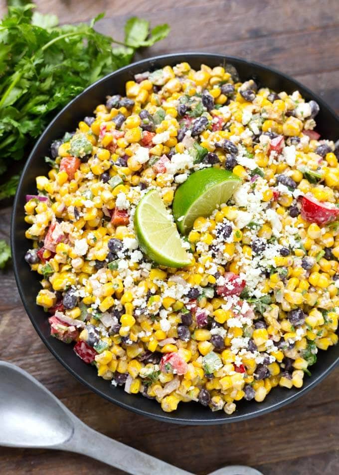 Mexican Street Corn Salad in a black bowl on a wooden surface