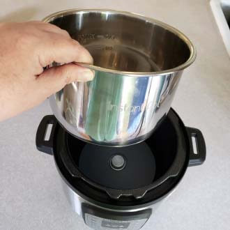 Placing the metal pressure cooker pot into the pressure cooker