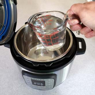 pouring water into the pressure cooker pot
