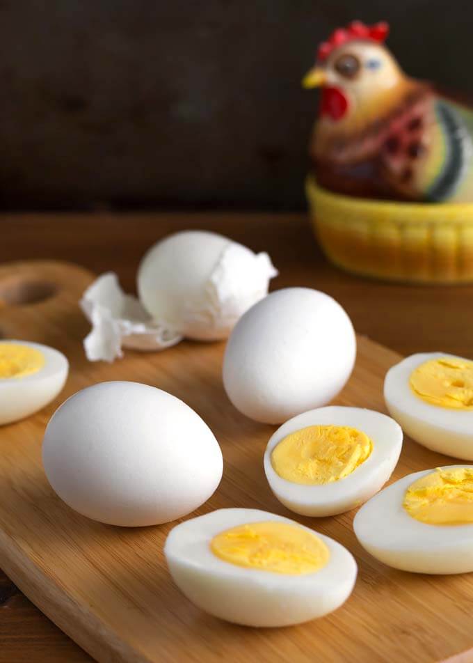 Air Fryer Boiled Eggs on wooden board in front of ceramic chicken