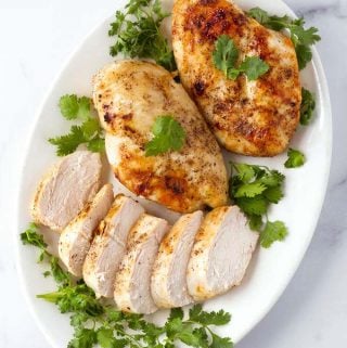Air Fryer Chicken Breasts on white plate garnished with parsley