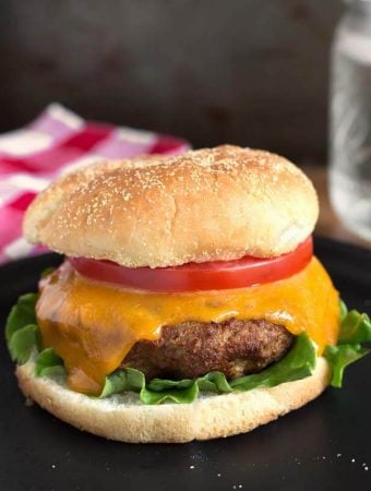 Air Fryer Turkey Burgers on black plate in front of red gingham napkin