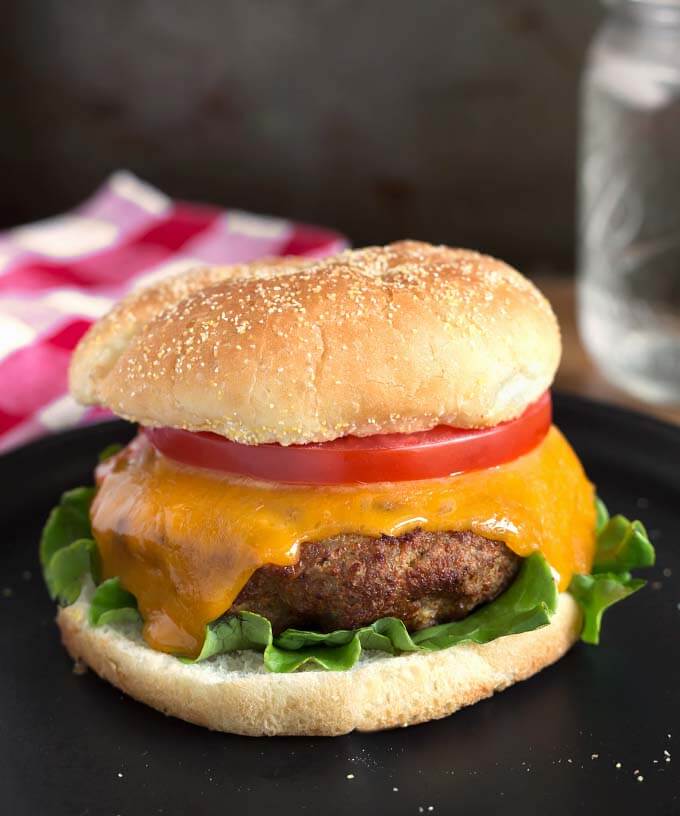 Air Fryer Turkey Burgers on black plate in front of red gingham napkin