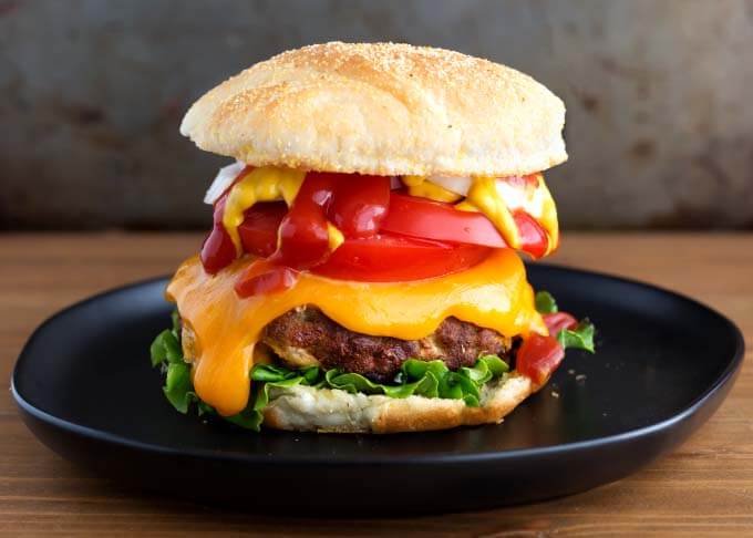 Air Fryer Turkey Burger on black plate on wooden surface