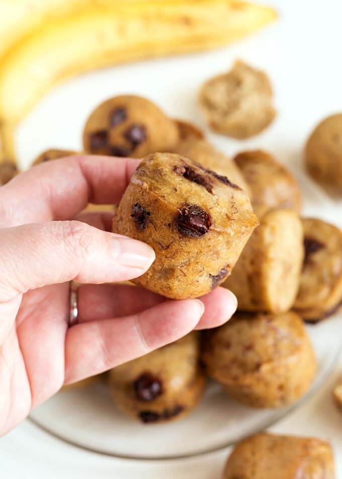 Hand holding a Banana Bread Bite above rest of Banana Bread Bites