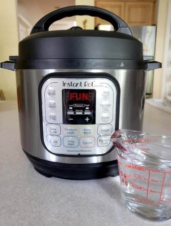 glass measuring cup in front of a pressure cooker