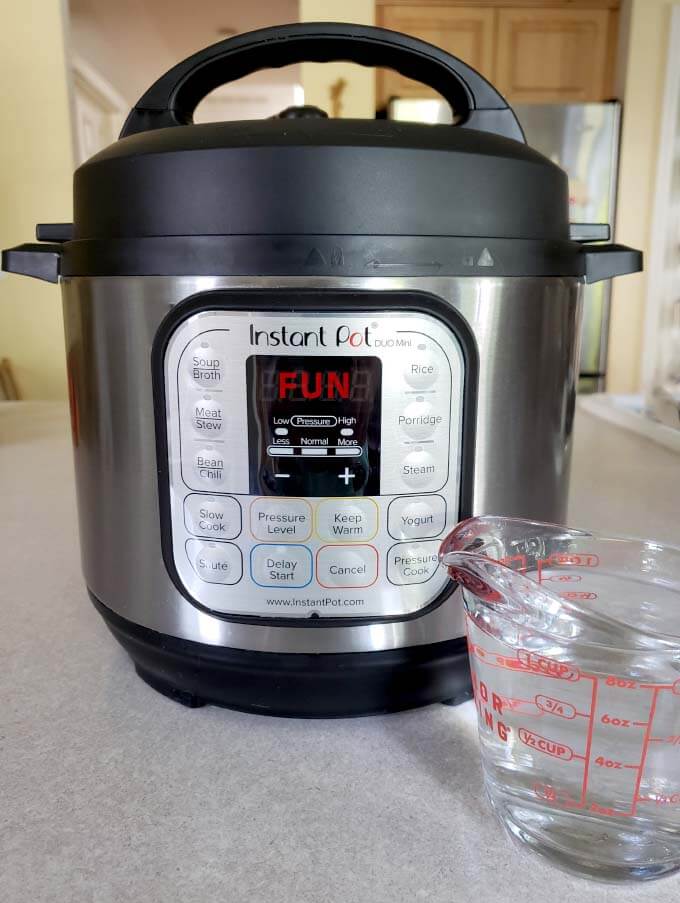 glass measuring cup in front of a pressure cooker