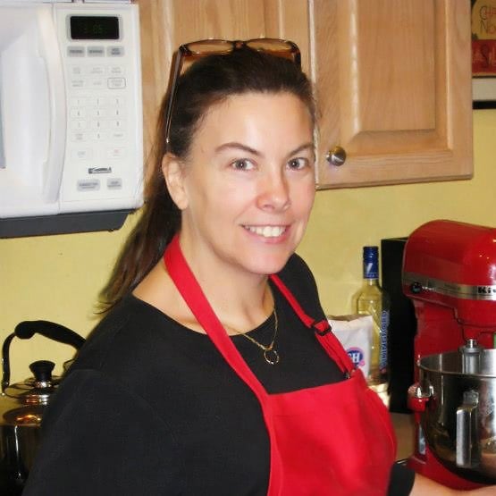 Sandy wearing a black shirt and a red apron