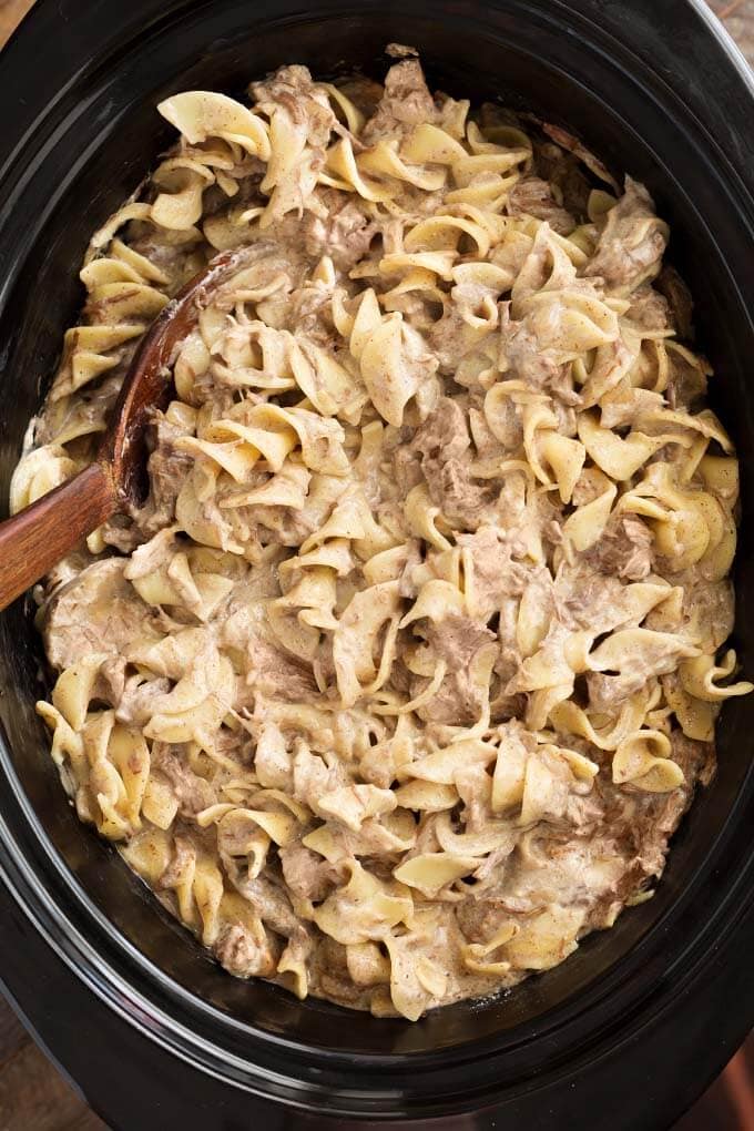 Beef Stroganoff with wooden serving spoon in slow cooker