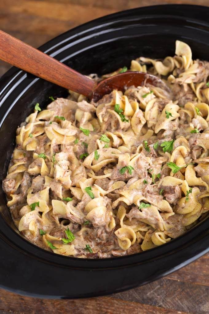 Beef Stroganoff in slow cooker with wooden serving spoon