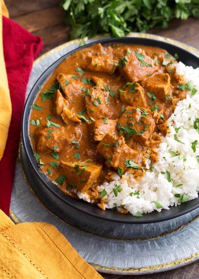 Indian Butter Chicken with rice on a black plate