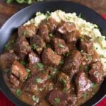 Beef Tips with mashed potatoes in a black bowl